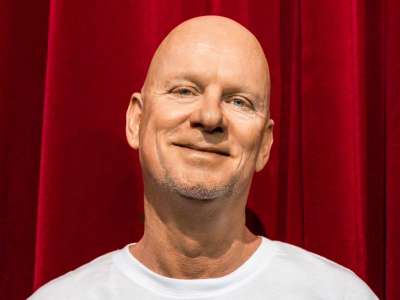 Rüdiger Hoffmann vor rotem Samtvorhang